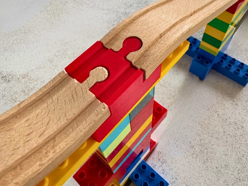 3D-gedruckter Adapter verbindet zwei Holzschienen auf einer Duplo-Brücke