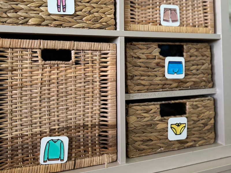 Ordnungs-Etiketten aus dem 3D-Drucker für Kleidung 3D-gedruckte Ordnungs-Etiketten mit Kleidungssymbolen an Körben im Kinderzimmer