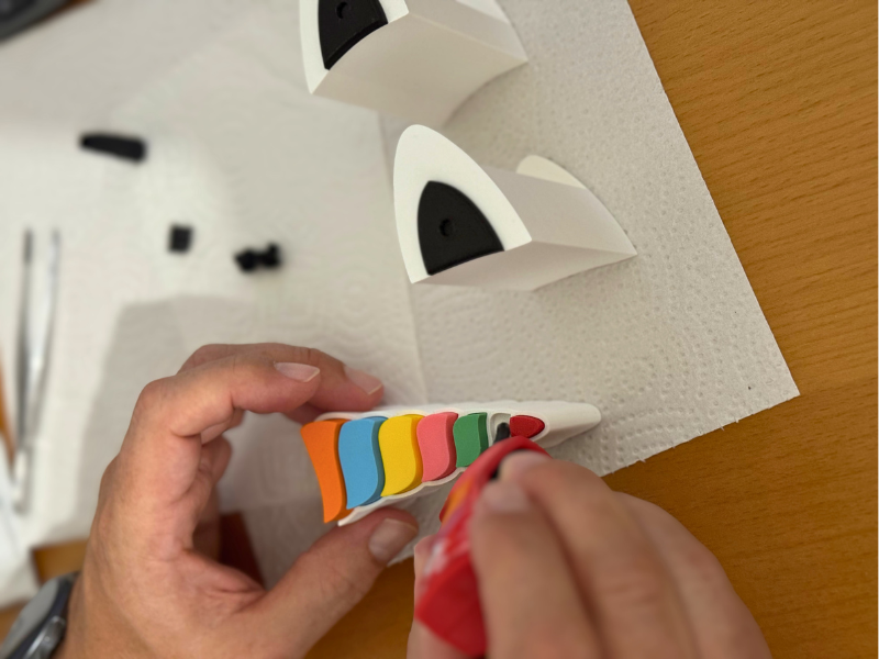 Hand bemalt ein 3D-gedrucktes Schmuckkästchen in Regenbogenfarben – kreatives DIY-Projekt für Kinder mit 3D-Druck.