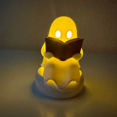 Lesender Geist – 3D-gedrucktes Nachtlicht mit magischem Glow 3D-gedrucktes Nachtlicht in Form eines lesenden Geistes mit leuchtenden Augen und Buch – stimmungsvolle Halloween- oder Kinderzimmer-Deko aus dem 3D-Drucker.