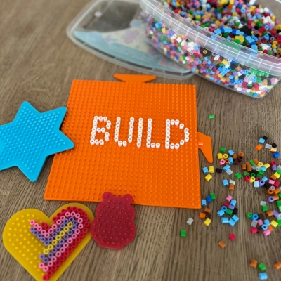 Kreativspaß mit Bügelperlen & 3D-Druck – DIY-Idee für Kinder Bügelperlen und Steckplatten in bunten Farben mit dem Schriftzug „BUILD“ – kreative Bastelidee für Kinder und Familien in Kombination mit 3D-Druck-Zubehör.