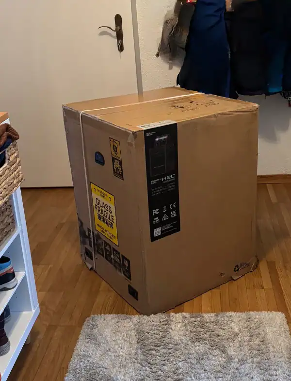 Großer Karton beim Unboxing des Bambu Lab H2C 3D-Druckers (the H2C) von Bambu Lab EU. Die Bambu Lab H2C Combo mit H2C AMS steht für multi-material and multi-color 3D, automatischen Hotend Change, Toolchanger, Servo Extruder, the nozzle-Präzision und the Vortek System. Die 65 °C aktiv beheizte Kammer reguliert die Temperature und minimizes warping and deformation while enhancing layer adhesion for high-performance Prints mit engineering filaments – flexible, precise und ohne unnötiges Purging.